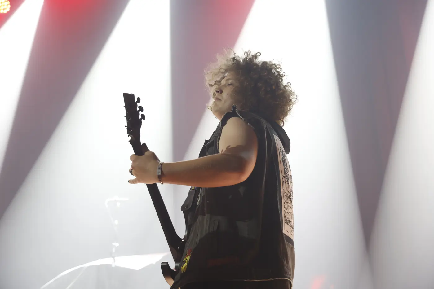 Guitarist silhouetted in beams of white light, black and white