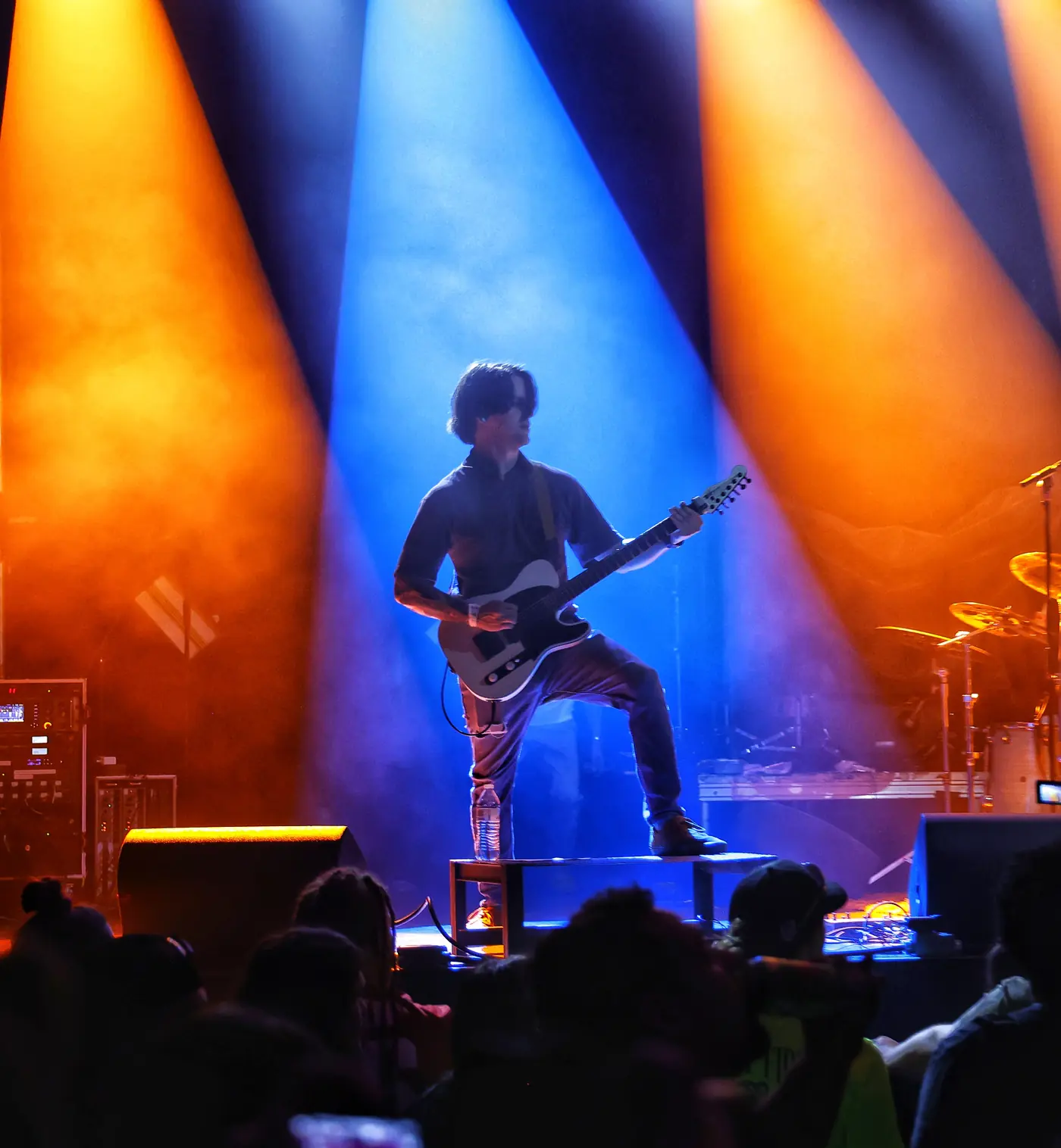 Guitarist performing under red and white stage lights